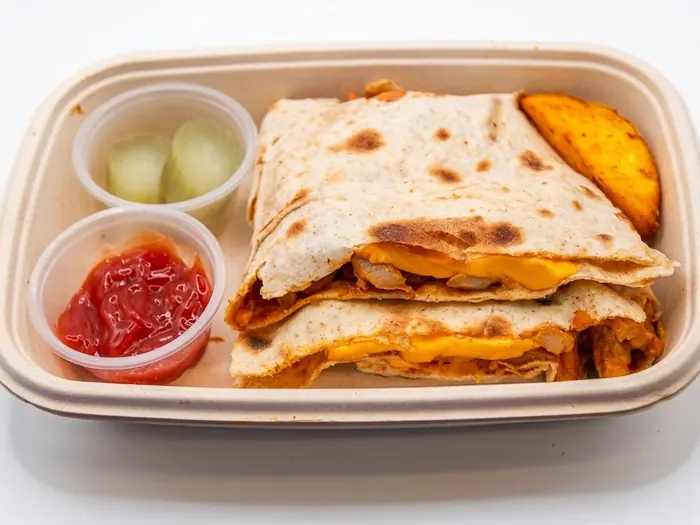 Chicken quesadilla with melted cheese and a potato wedge