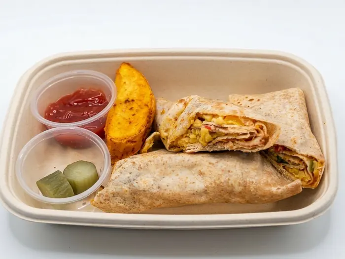 Egg sandwich wraps with a potato wedge, pickles and ketchup