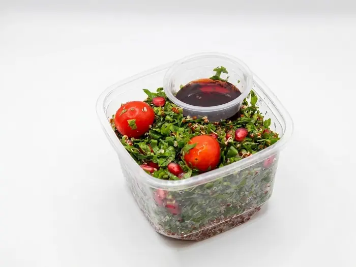 Chopped herb and quinoa salad with pomegranate, cherry tomato and tahini dressing